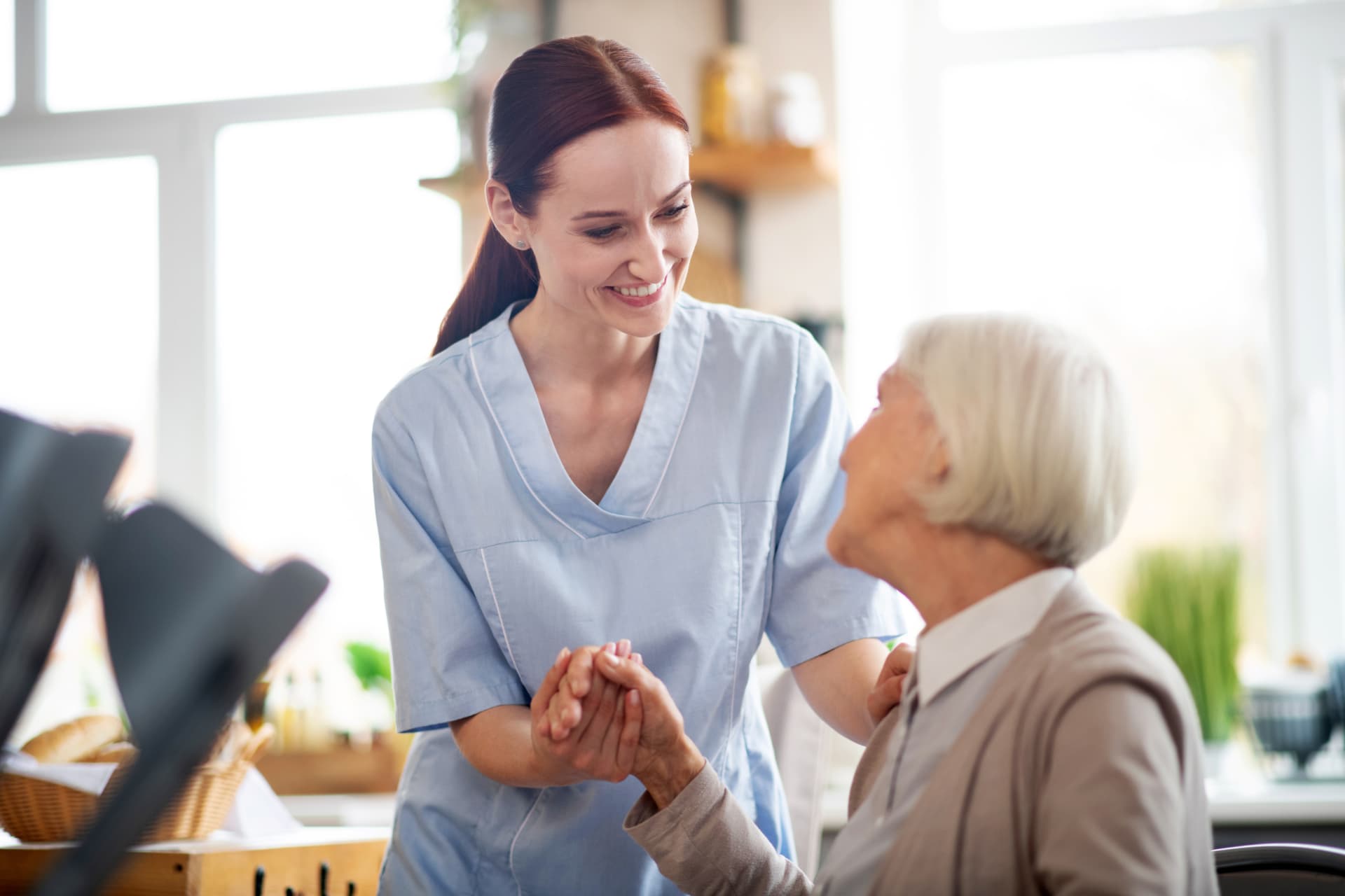 Pflegekraft im persönlichen Gespräch mit einer Seniorin